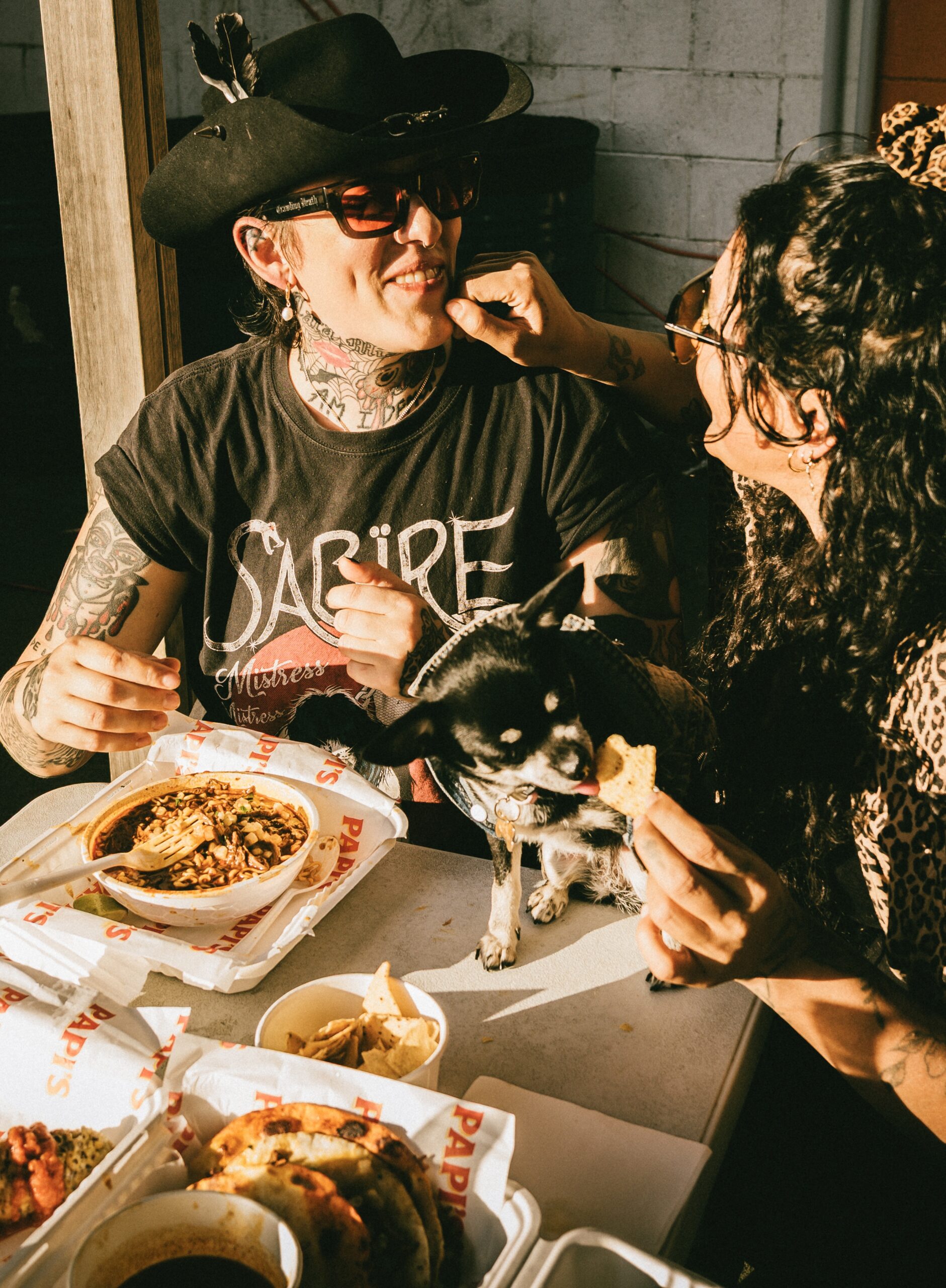 A couple and their Chihuahua, enjoying a Mexican meal together.